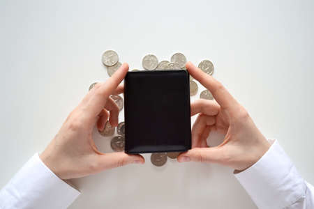 Purse in hand against a background of coins. The concept of financial crisis, the accumulation of money. economic crisis. Strengthening of the ruble.の写真素材