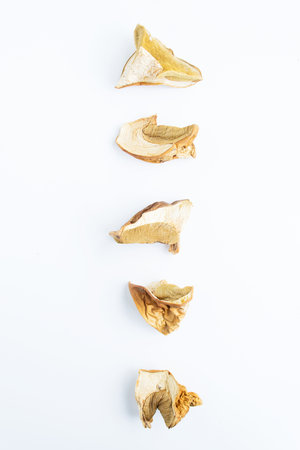 Dried porcini mushrooms cut in pieces on a white background. Dried mushroom setの写真素材