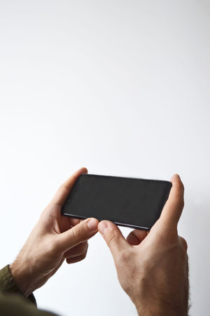 Close-up of male hands using a mobile smartphone. Phone in men's hands. Layout of an image of a cell...