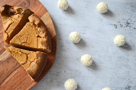 Pumpkin pie cheesecake cut into slices on a wooden tray.