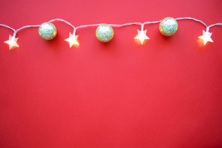 Red Christmas background with garland and golden balls.