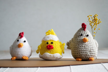 Easter Crochet chickens and chicken with mimosa on light background.の写真素材