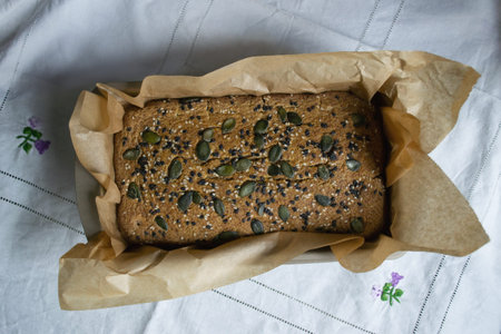 Hot homemade bread with sesame and pumpkin seeds on a tablecloth, freshly baked in the oven....