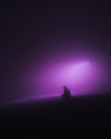 Silhouette of a man sitting in purple fog with dramatic light and moody atmosphereの素材