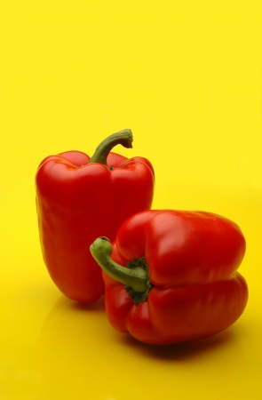 Red bell peppers on yellow kitchen counterの写真素材