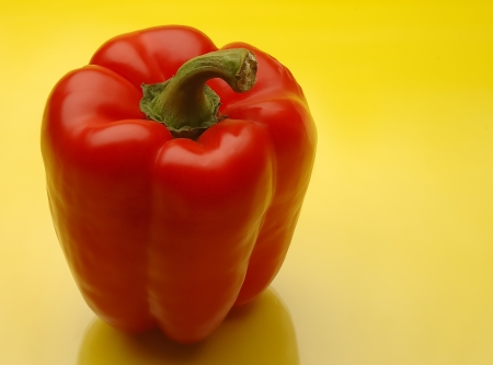 Red bell peppers on yellow kitchen counterの写真素材