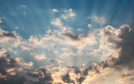 Suns rays beaming from behind cloudsの写真素材