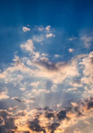 Suns rays beaming from behind cloudsの写真素材