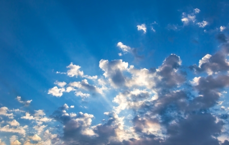 Suns rays beaming from behind cloudsの写真素材
