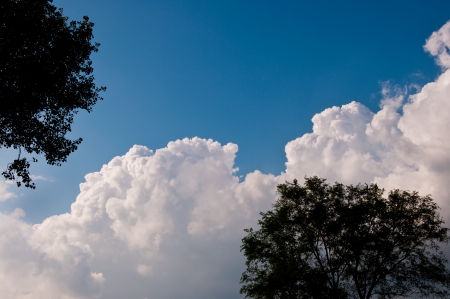 Storm clouds rolling past clear skiesの写真素材