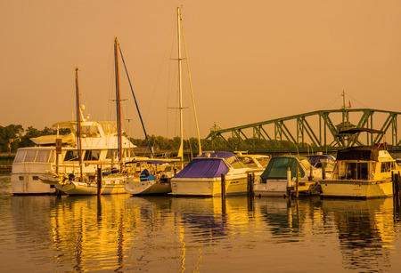 Golden glow on marina boats and waterのeditorial素材