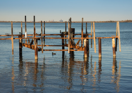 setting sun glow on old wooden dock slipの写真素材