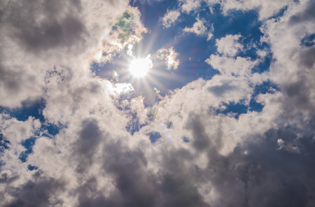 Suns rays beaming from behind cloudsの写真素材