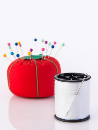 Tomato pin cushion and spool of threadの写真素材