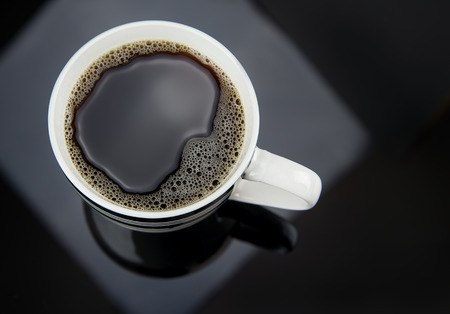 Fresh Coffee pouring into fancy cup on table topの写真素材