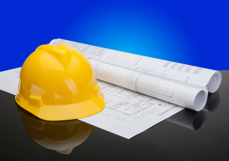 Construction site safety gear and tools with blueprints