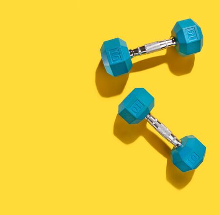 Blue Hand Weights with Shadow on Yellowの写真素材