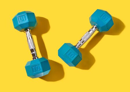 Blue Hand Weights with Shadow on Yellowの写真素材