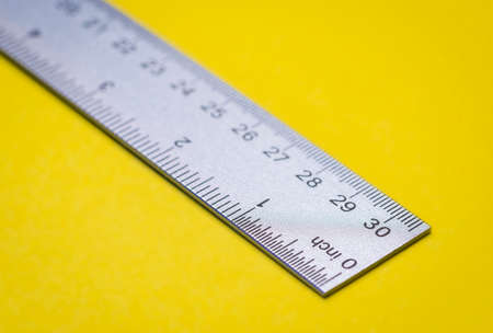 Metal ruler tool on yellow for school or officeの写真素材