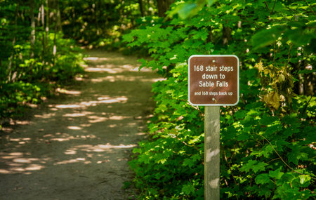 Funny Sign for distance to Sable falls attraction on woods trail head Northern Michigan parkの写真素材