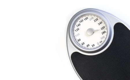 Mechanical weight scale close-up with graduated dial for weight measurement.の写真素材