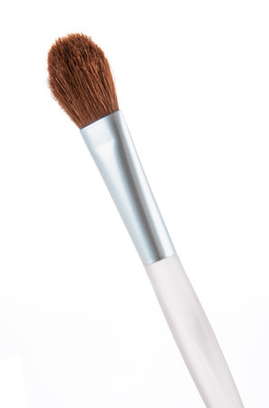 Top view of a makeup brush showing its soft, brown bristles and sleek white handle, perfect for applying eyeshadow or other cosmetics. Ideal for beauty projects and makeup tutorials.の写真素材