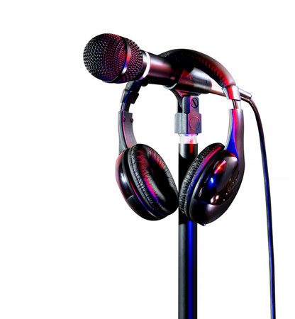 A detailed photograph of a microphone attached to a stand, accompanied by a pair of headphones neatly placed over the microphone setup, with vibrant lighting on a clean white background for contrast.の写真素材