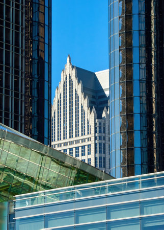 An urban photograph showcasing a modern cityscape. The image details reflective skyscrapers, combining contemporary and traditional architecture styles, set against a vibrant blue sky.の写真素材