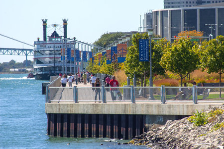 View of the Detroit Riverfront featuring a ferry boat and city skyline on a clear summer dayの写真素材