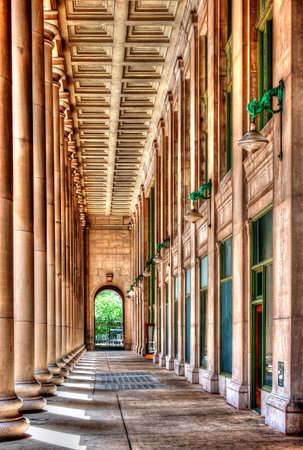 A stunning corridor showcasing grandeur and symmetry, framed by tall columns and intricate architectural details. This historical structure exudes a sense of elegance and timelessness in urban design.の写真素材