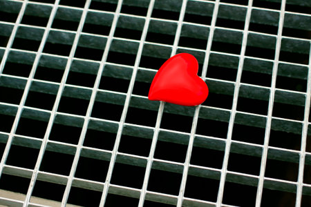 Red heart on a metal grid