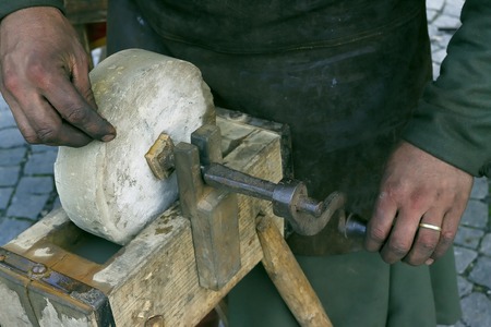 Blacksmith grinding on hand brushesの写真素材