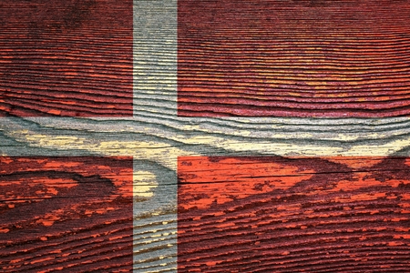The flag of Denmark is painted on a wooden board with a wooden structureの写真素材