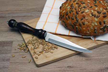 Bread with a knife on a wooden cutting board