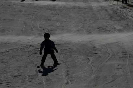 Silhoutte of young skier as he/she snowplows down the mountainの写真素材