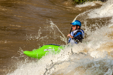 Salida, USA - June 20, 2015: Professional freestyle kayaker at the 2015 FIBArk Freestyle Whitewater Rodeo competiton at Riverside Park, Arkansas River, Salida, Colorado. This kayaker is competing for points in the Freestyle Pro Semi-Finals event.のeditorial素材