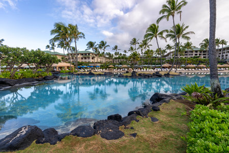 Palm trees reflect in the beautiful turquoise water of one of the luxurious swimming pools at the Grand Hyatt Kauai Resort and Spa in Koloa, Hawaii.のeditorial素材