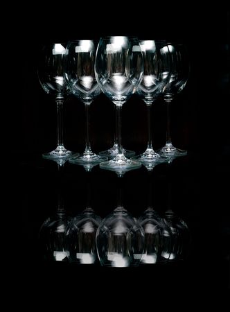 Glasses for wine on a glass shelf on black.の写真素材