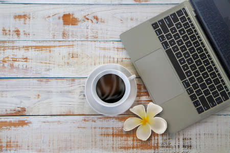 Top view of Espresso or americano, black coffee cup and  laptop computer on white wooden background with copy spaceの写真素材
