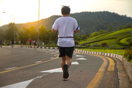 Men jogging in the morning out on the  track. in public parkの写真素材
