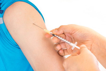 Doctor giving an injection to a patient の写真素材