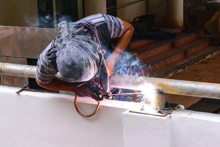 worker use electric welding connecting construction metal 