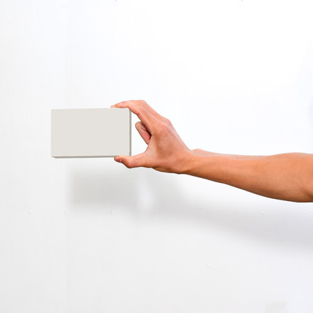 hand holding blank paper business card, closeup  on white backgroundの写真素材
