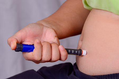 patient is injecting Insulin with a Insulin Penの写真素材