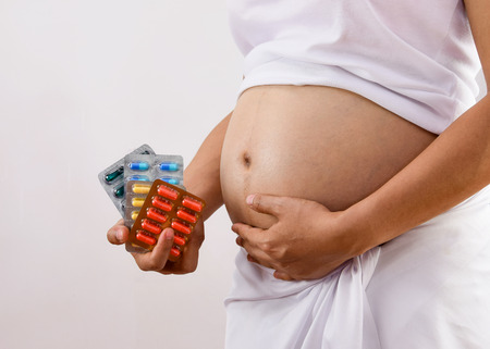 Pregnantcy woman holding medicineの写真素材