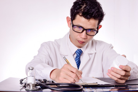 Close-up Of Male Doctor Filling The Medical Formの写真素材