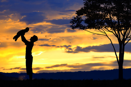 Father day background,Father and baby silhouettes play at sunset  mountains  blurred backgroundの写真素材