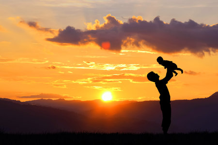 Father day background,Father and baby silhouettes play at sunset  mountains  blurred backgroundの写真素材