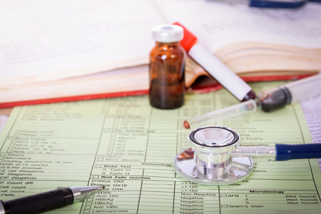 Close up of  stethoscope on form to fill in the results of biochemistry blood tests with book and  vialの写真素材