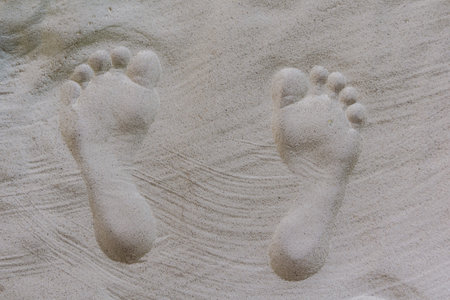 Two well-shaped shaped human footprints in the sand